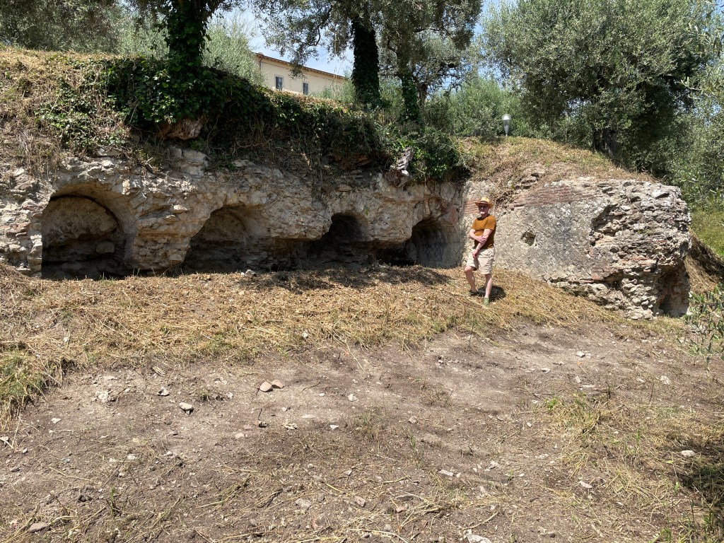 View of the arched Roman terrace wall at the Via Belvedere site; Prof. Foss is in the foreground and the adjacent water channel is behind him.